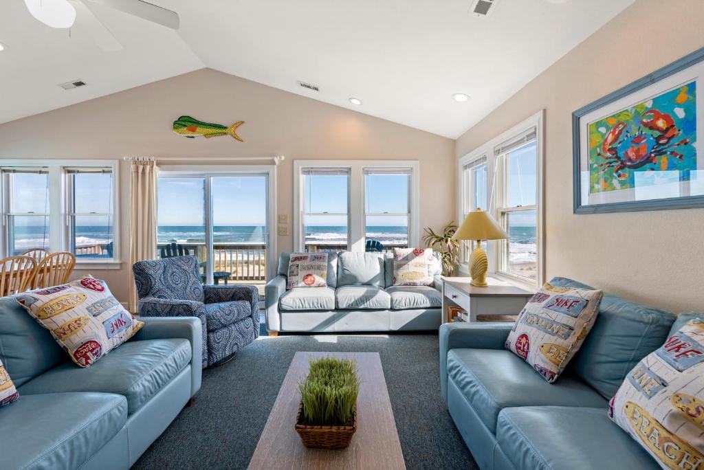 a living room with blue couches and the ocean at Oceans Edge in Nags Head