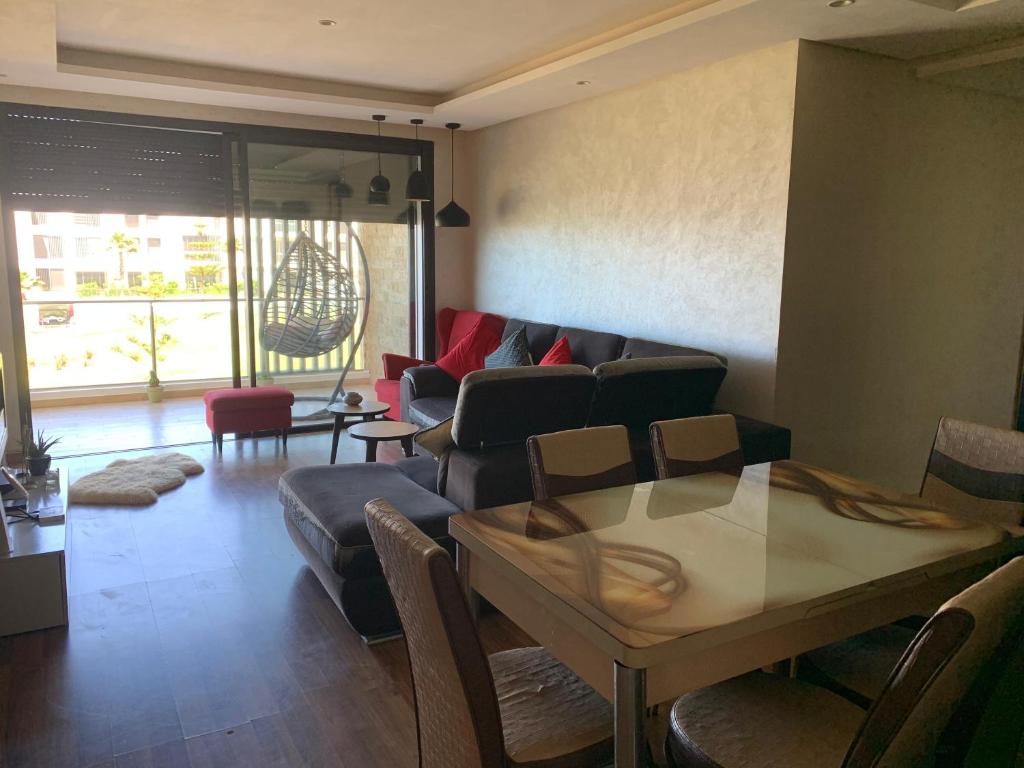 a living room with a couch and a table at Prestigia plage des Nations in Sale