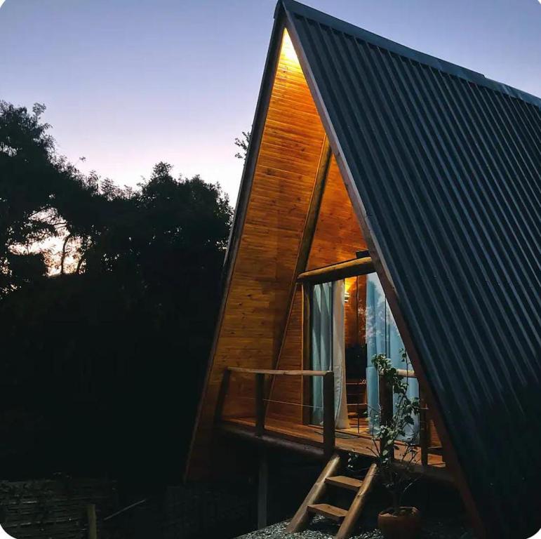 une petite maison avec une fenêtre et une échelle dans l'établissement Chalé Gênova - Recanto da Pedra, à São Bento do Sapucaí