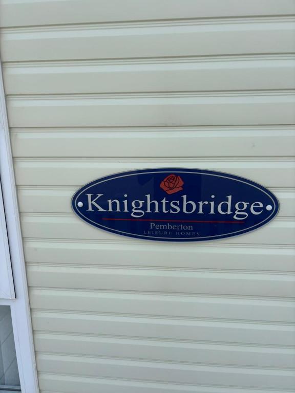 a blue sign on the side of a garage at Knightsbridge 2 Bedroom Lodge in Lytchett Minster