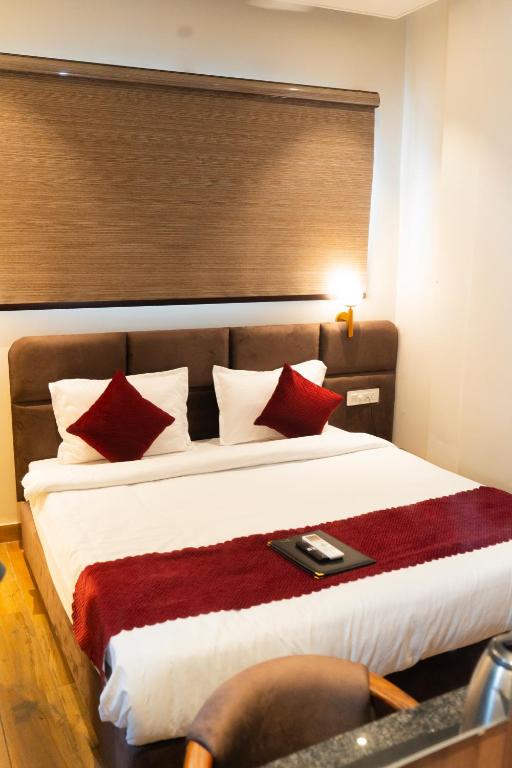 a bedroom with a large bed with red pillows at Hotel RK Heights 300M HOTEL TO GOLDEN TEMPLE in Amritsar