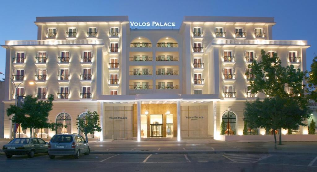 a white building with cars parked in front of it at Volos Palace in Volos