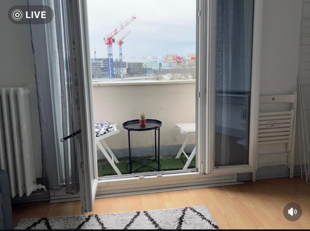 Cette chambre dispose d'un balcon avec une table et une fenêtre. dans l'établissement Appart Plein Soleil Seine Paris 5ème Jardin Plantes, à Paris