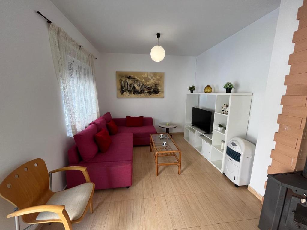a living room with a red couch and a tv at Villa Alcázar in San Pedro del Pinatar