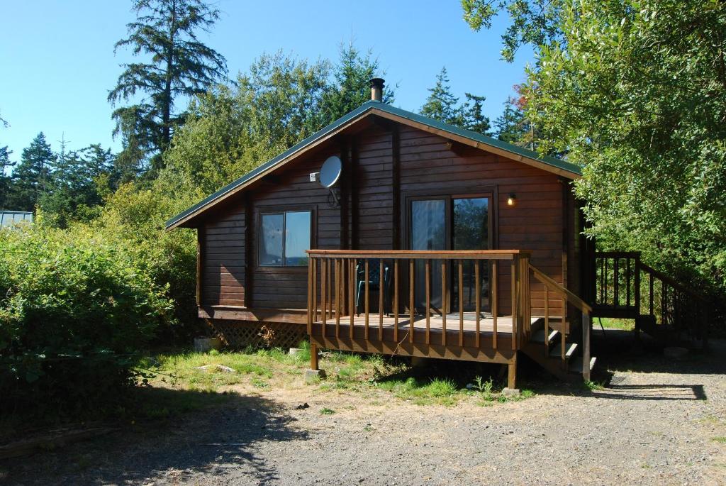 Cabaña de madera con porche y terraza en La Conner Camping Resort Deluxe Cabin 5, en La Conner