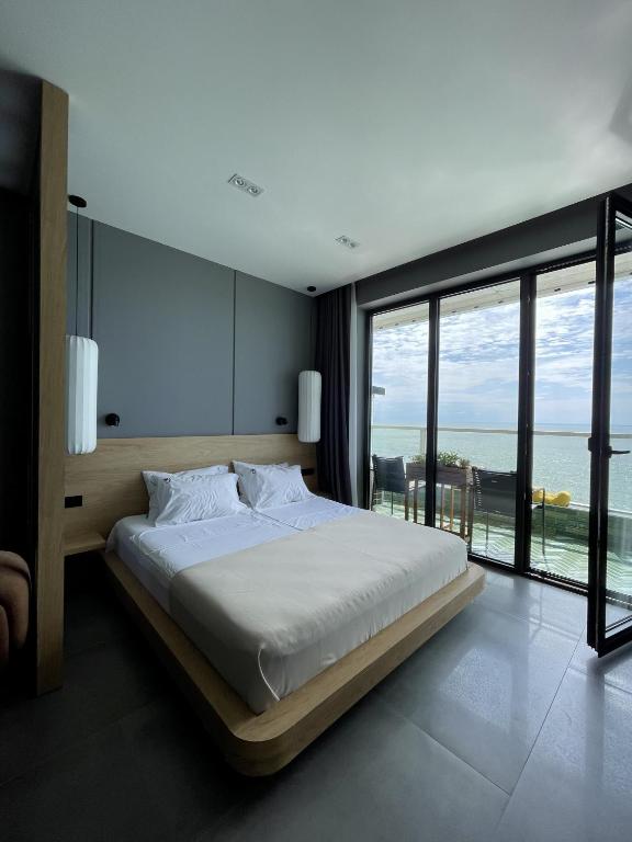 a bedroom with a bed with a view of the ocean at Bamboo Beach Tsikhisdziri, Solmare Loft in Itʼkhvisi