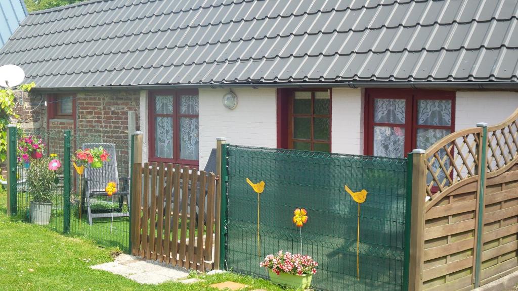 a fence in front of a house with flowers on it at Gite Les Oiseaux in Le Tréport