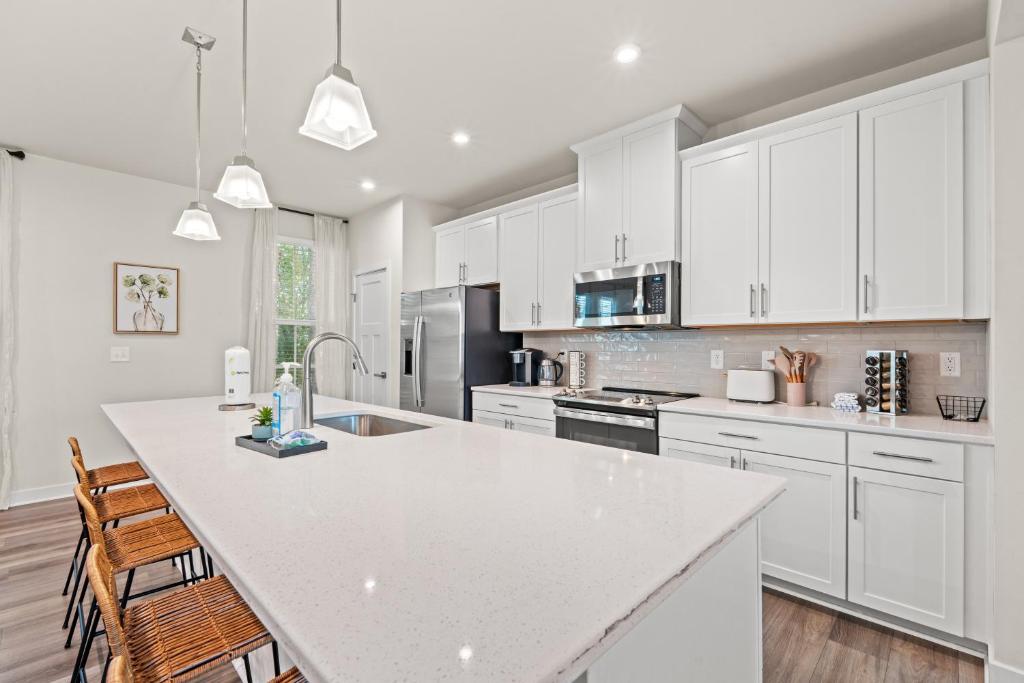 Una cocina con gabinetes blancos y una encimera blanca. en Dye Estates Luxury Home , Spacious Barefoot Landing Getaway, en North Myrtle Beach