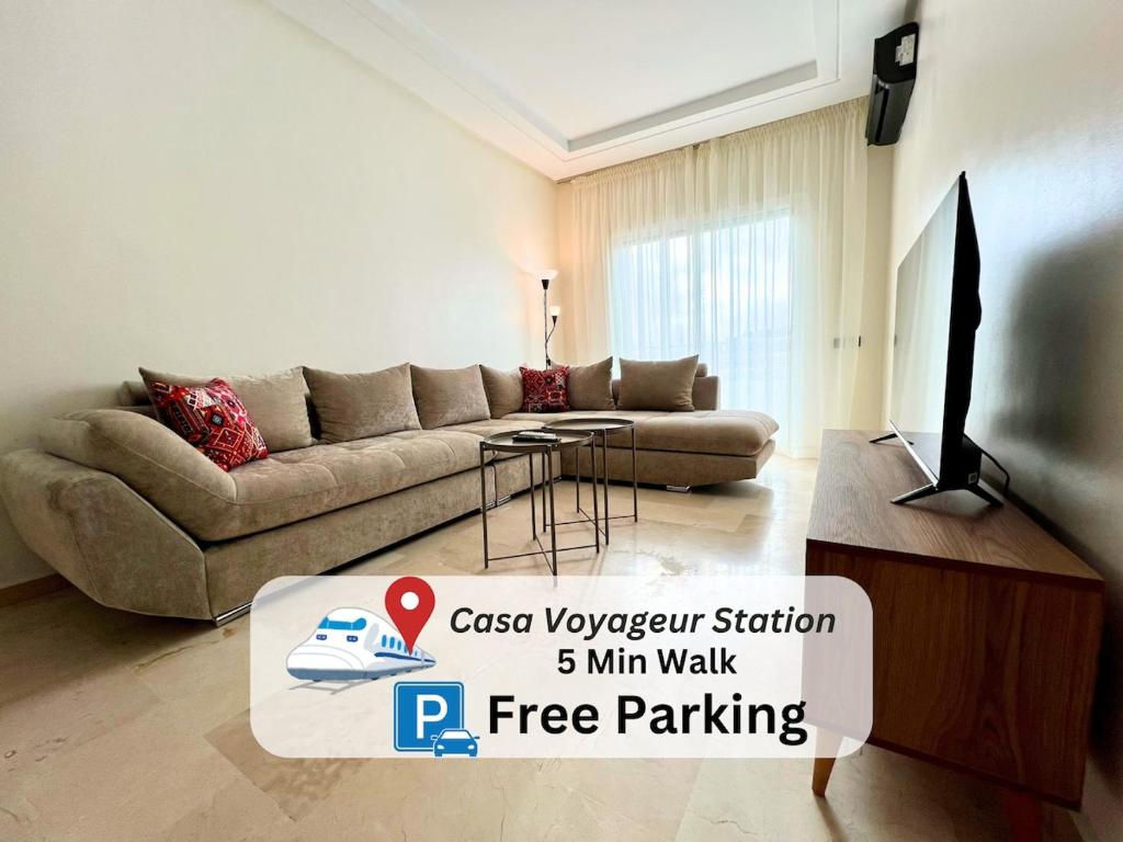 a living room with a couch and a television at Casablanca Central Suites - Casa Voyageurs in Casablanca