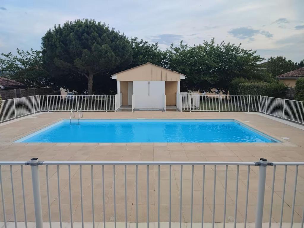 une grande piscine bleue avec une clôture blanche dans l'établissement Le Parc, T3 climatisé, Parking, Piscine, à Carcassonne