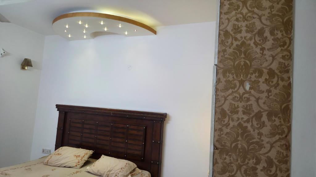 Un dormitorio con una cama con cabecero marrón. en Sterling East Apartment, en Bangalore