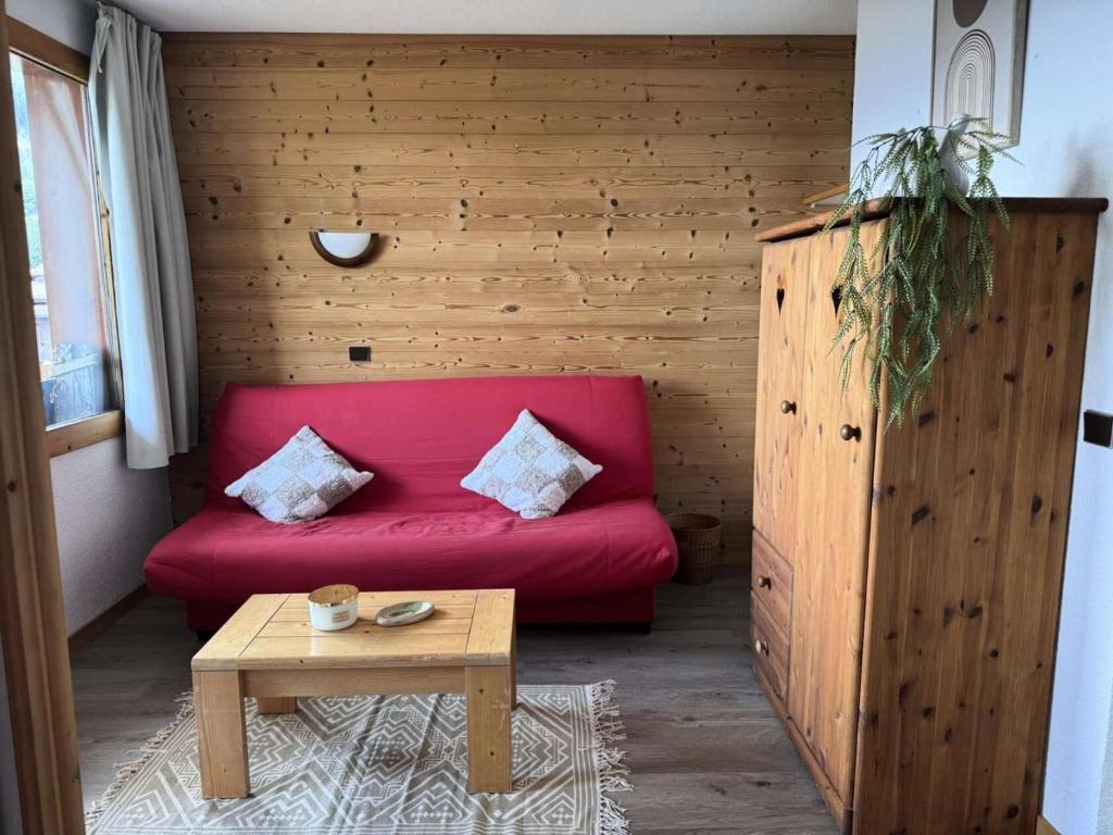 - un canapé rouge dans une chambre avec une table dans l'établissement Résidence Roche Combe - Le Roche Combe 10 - Agréable studio divisible offrant une magnifique vue sur la vallée MAE-4984, à Valmorel