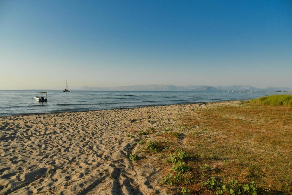 a beach with a boat in the water at 50 Steps From the Sea in Lefkimmi