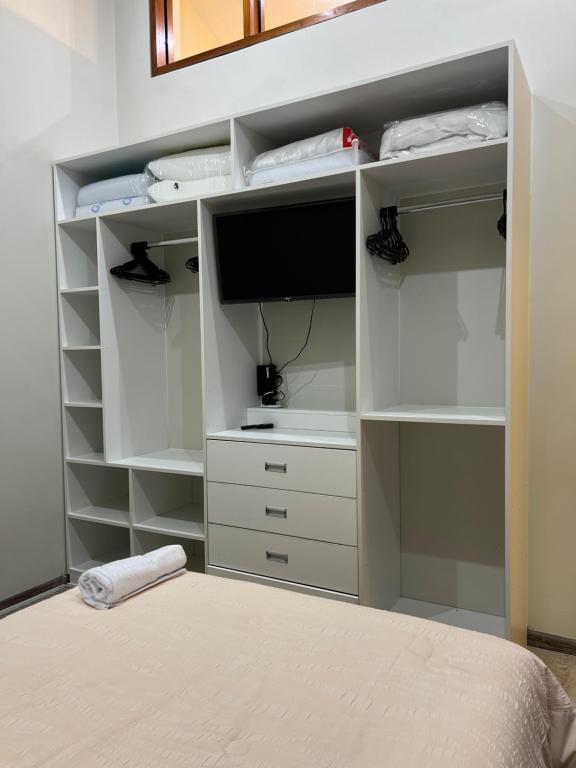 a bedroom with a white closet with a tv and a bed at Departamento en Plaza Mayor de Ayacucho in Ayacucho