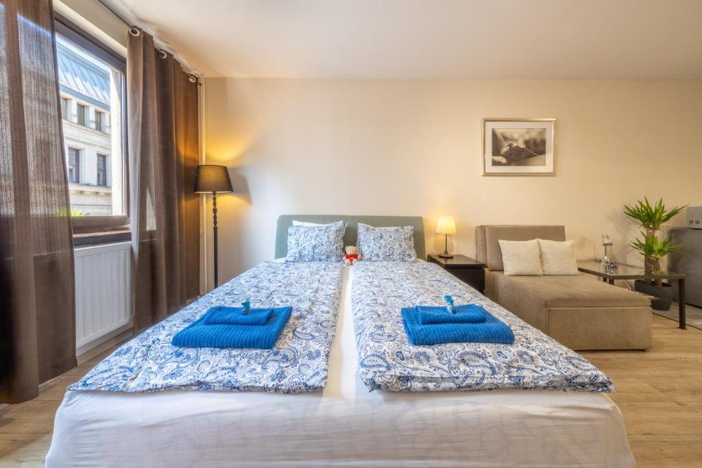 a bedroom with a large bed with blue pillows on it at Gloria Apartment in Budapest