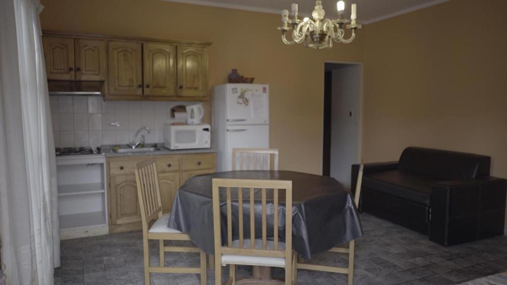 a kitchen with a table and chairs and a refrigerator at Cabañas María CAROLINA in San Luis