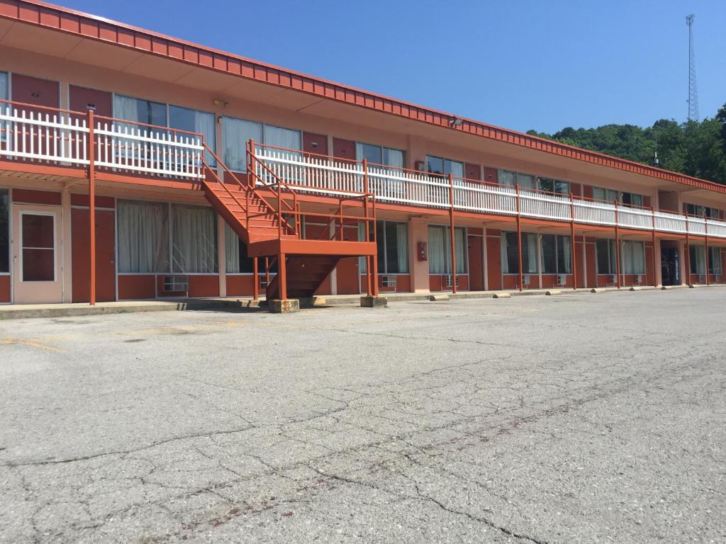 ein großes rotes Gebäude mit Treppen auf einem Parkplatz in der Unterkunft Daniel Boone Motor Inn in Pikeville