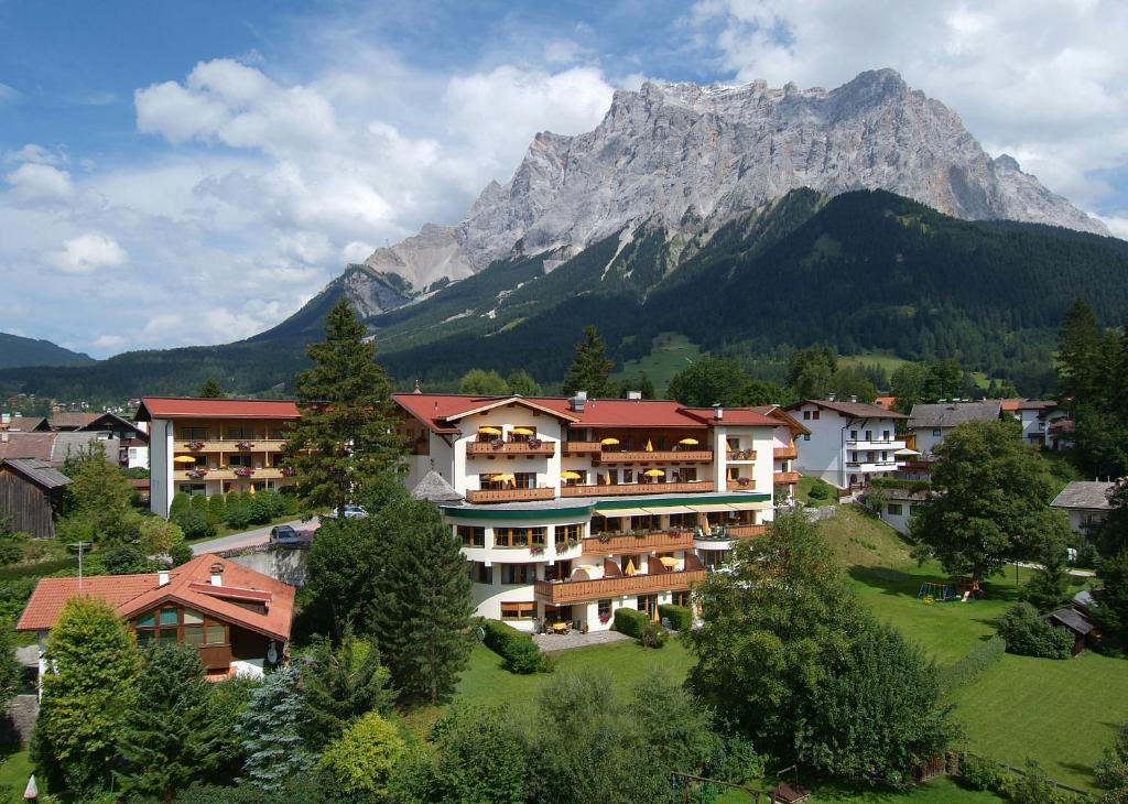 ein großes Gebäude mit einem Berg im Hintergrund in der Unterkunft Sporthotel Schönruh in Ehrwald