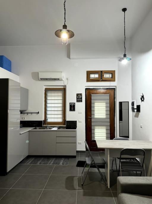 a kitchen with a table and some chairs in a room at La casina di Stellatattoo in Crotone