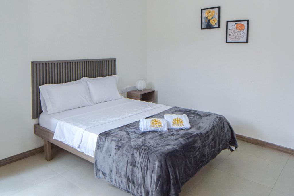a bedroom with a bed with two pillows on it at Hotel Fuente Real in Popayan