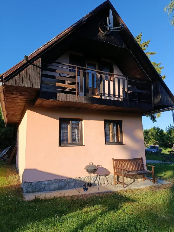 a house with a bench and a balcony at Chata Carla in Žiar