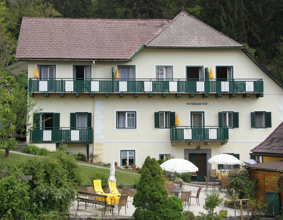 a large white building with tables and chairs in front of it at Petersenhof in Millstatt