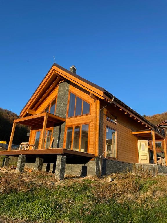 a wooden house with glass windows on a hill at Horne Hamre lodge in Horné Hámre
