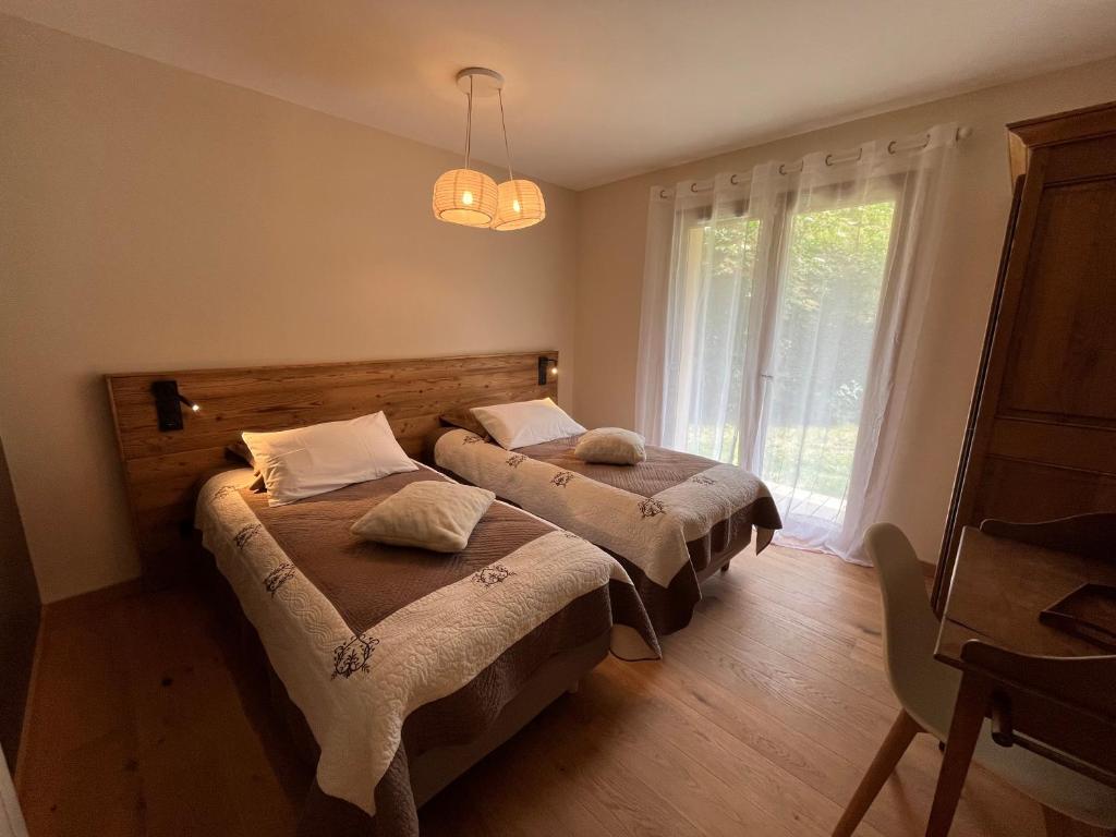 two beds in a room with a window at Gîtes du Grand Replomb in Sainte-Agnès