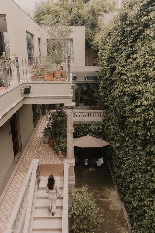 a woman walking down the stairs of a building at Casa Seis Siete in Mexico City