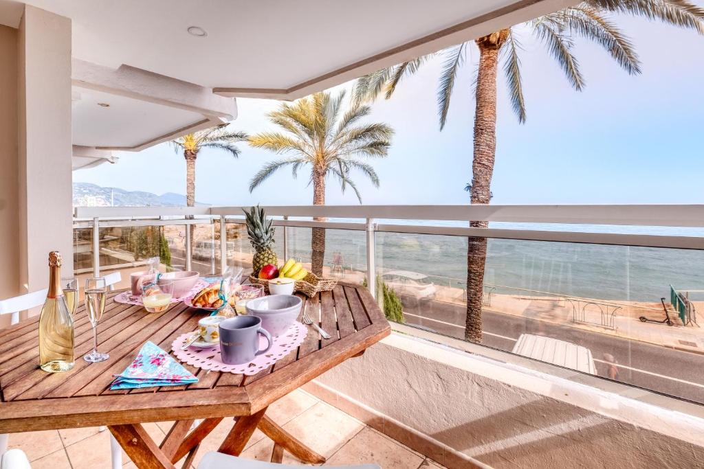 - une table sur un balcon avec des palmiers et l'océan dans l'établissement Rives d'Azur Apt - Happy Rentals, à Menton