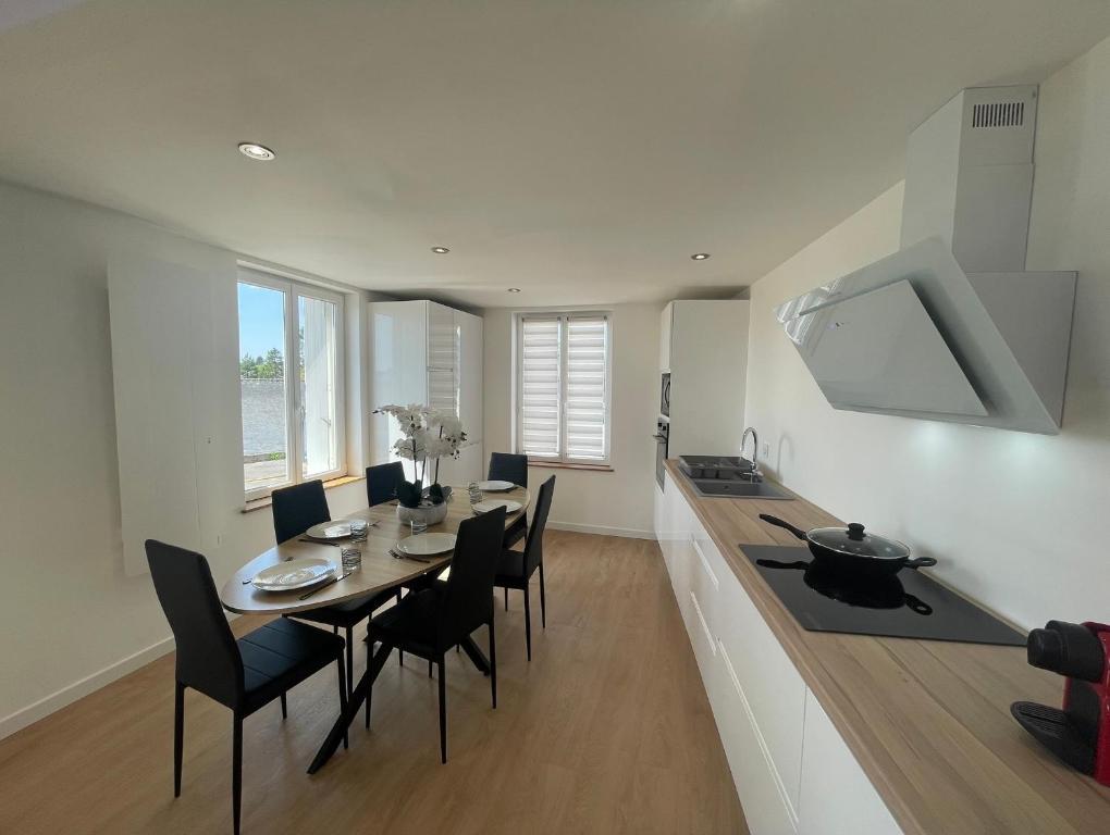 une salle à manger avec une table et des chaises dans une cuisine dans l'établissement Maison T3 proche MER - Ideal en famille ou entre amis, à La Forêt-Fouesnant