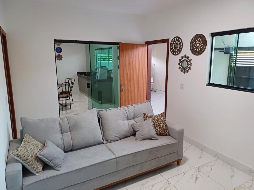 a living room with a gray couch in a room at Casinha top perto Águas Quentes in Barra do Garças