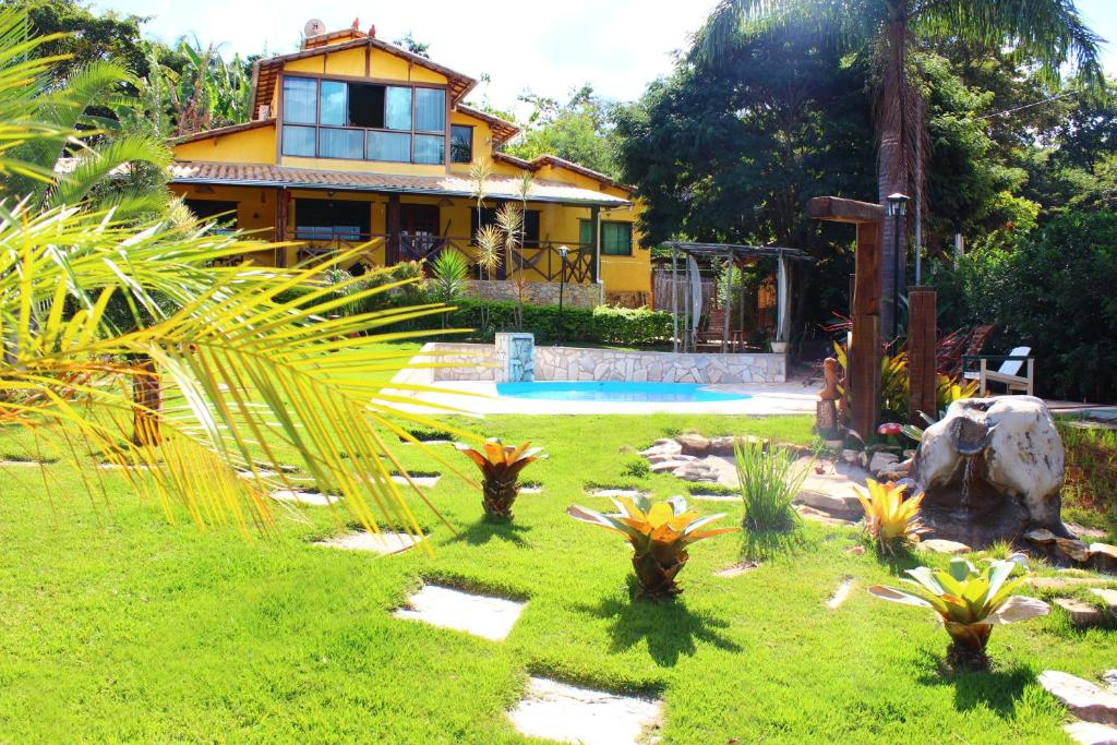 una casa con un patio con plantas delante en Pousada Luar do Cipó, en Serra do Cipo