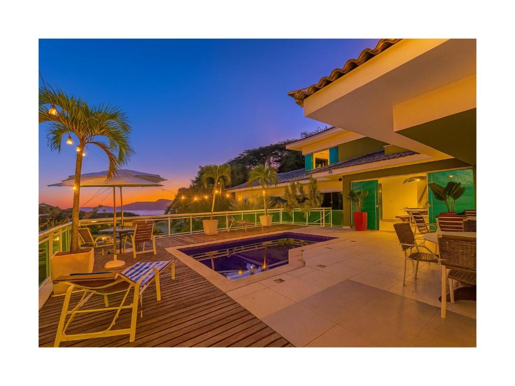 a house with a deck with a swimming pool at Palmares, Casa de praia in Búzios