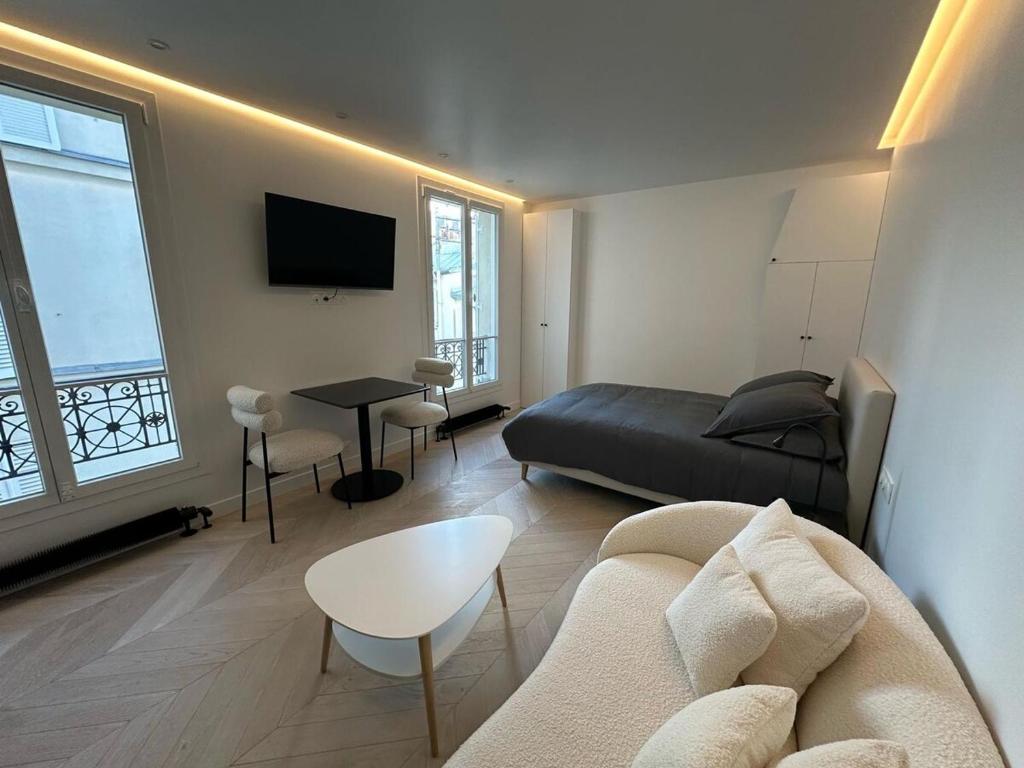 un soggiorno con un divano e un letto di Luxury Apartment Champ de Mars Eiffel Tower a La Celle-sous-Gouzon