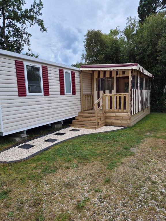 a mobile home with a porch and a deck at Mobil home 3 chambres tout équipé avec accueil humain in Pont-Aven