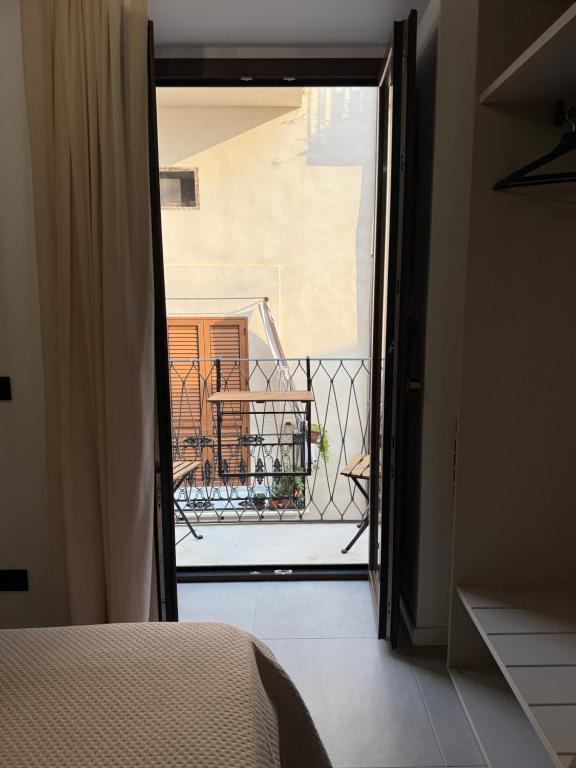 a bedroom with a door open to a balcony at Aria Suites Cefalù in Cefalù