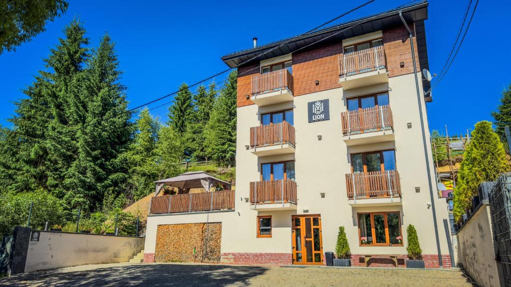 a tall white building with balconies on it at Lion in Bukovel