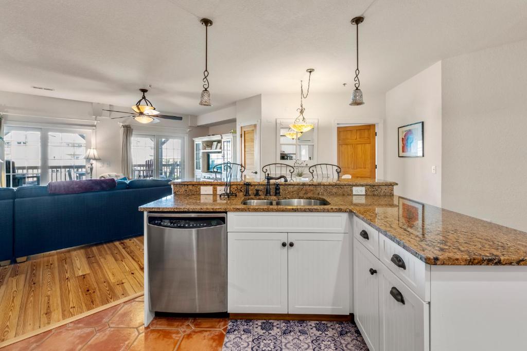 Una cocina con fregadero y una sala de estar. en Ts Retreat, en Kill Devil Hills