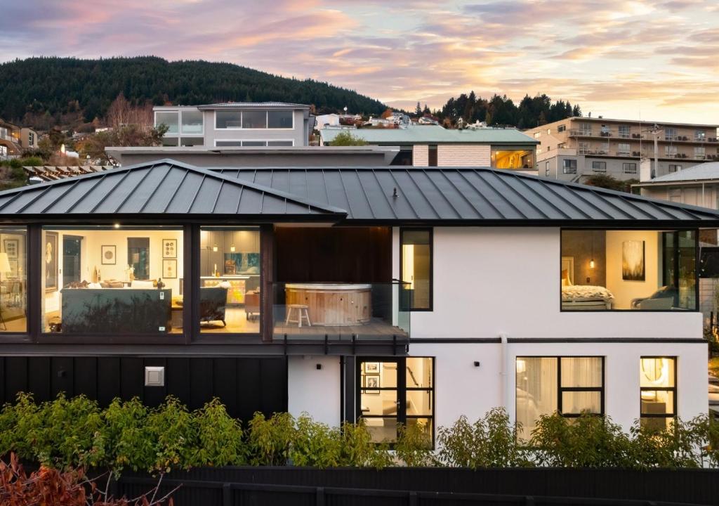 una casa bianca con il tetto nero di The Glasshouse by MajorDomo - Central Home with Hot Tub & Sauna a Queenstown