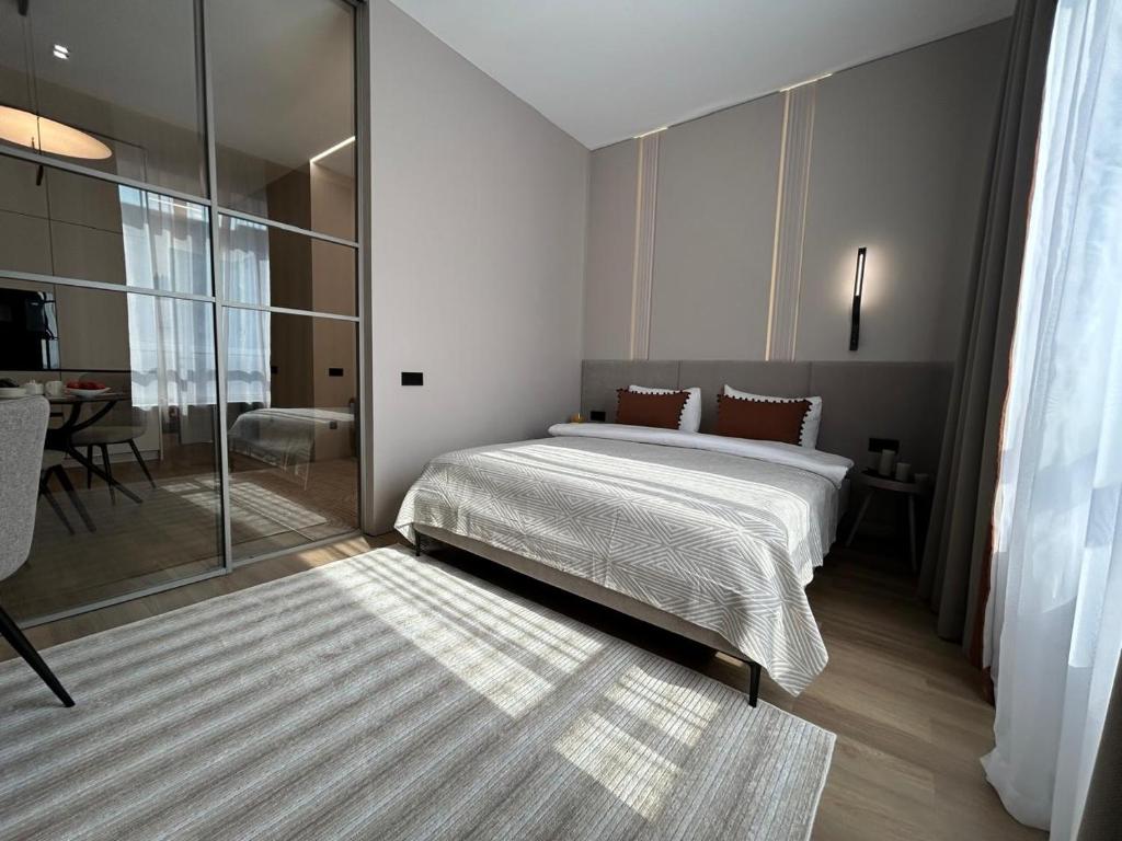 a bedroom with a bed and a glass wall at Apart Complex Meridian из 10 отдельных апартаментов рядом с Арбатом in Almaty