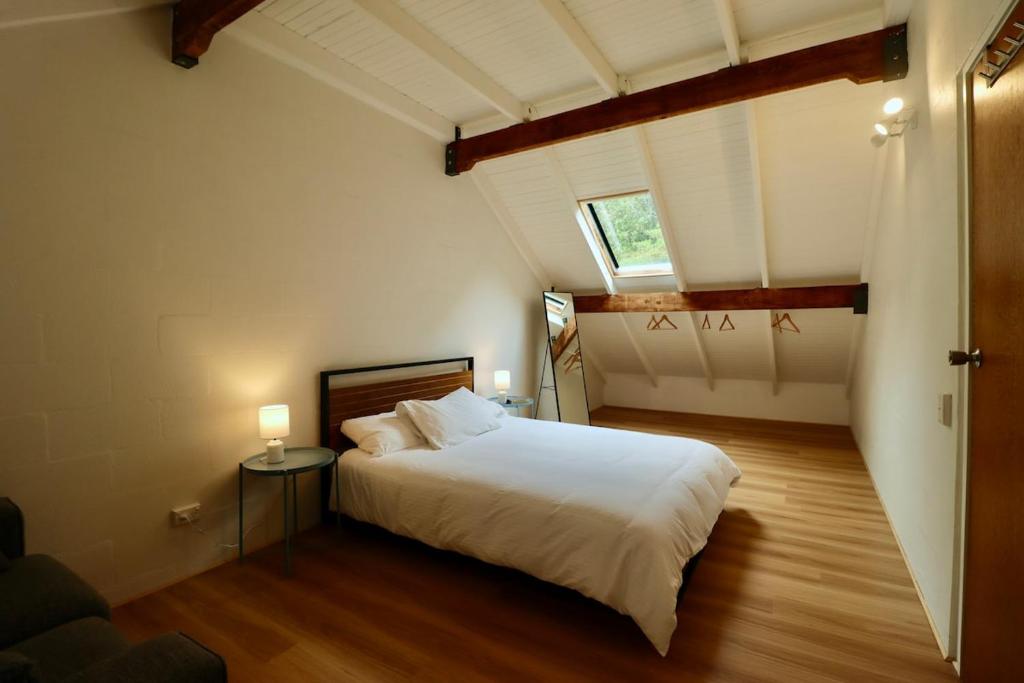 a bedroom with a large white bed and a window at Maleny-Montville Cottages #1 - 2 bed ocean views in Balmoral Ridge