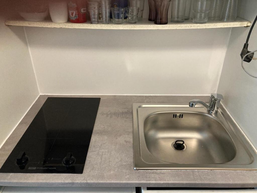 a kitchen counter with a sink and a shelf at Studio lit 90 avec balcon in Gradignan