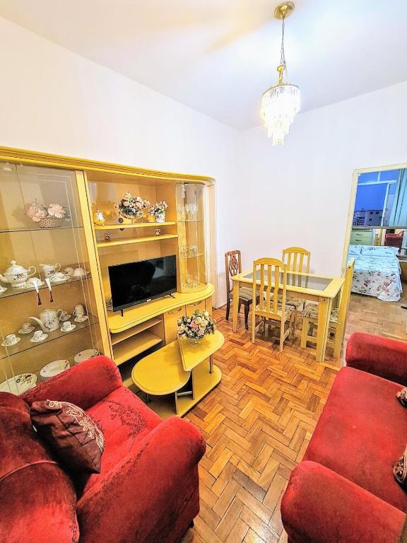 a living room with a red couch and a table at Radiante Amanhecer! in Belo Horizonte