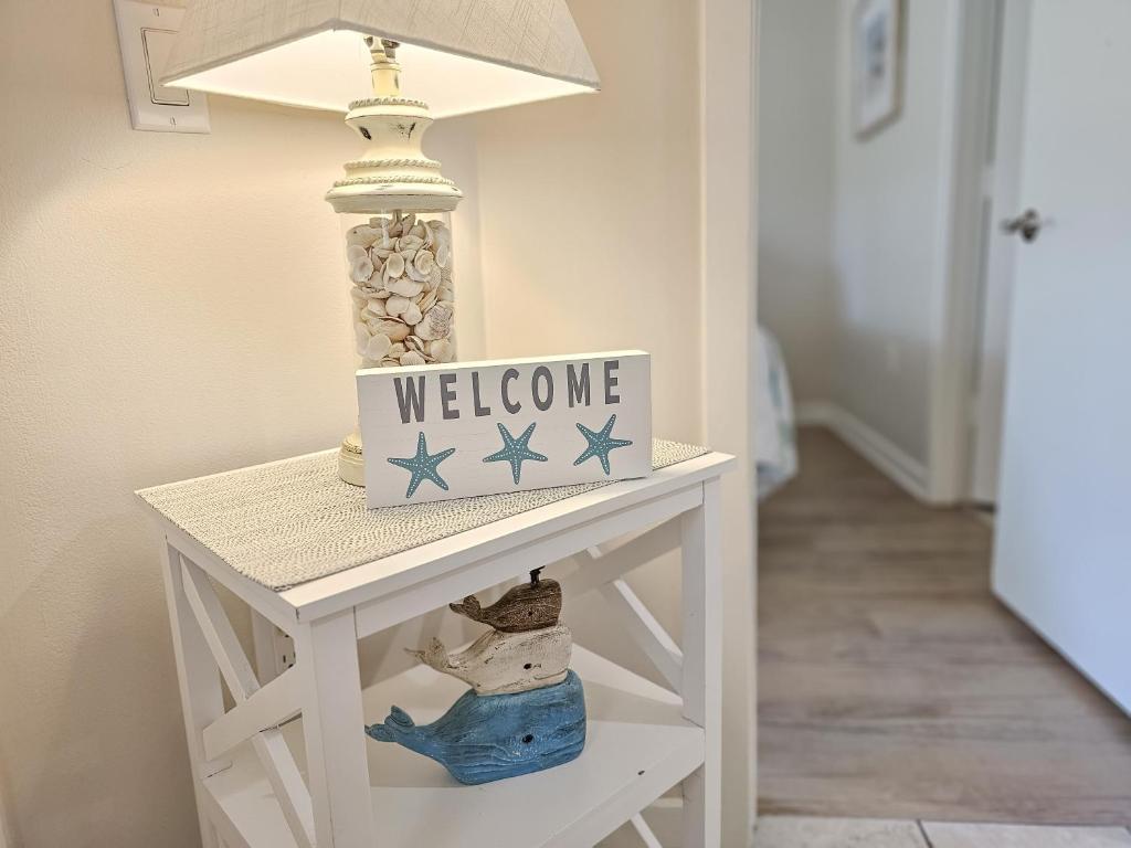 ein weißer Beistelltisch mit einem Willkommensschild darauf in der Unterkunft Serene 2 bed, 2 bath lodge, with amenities, 101AC lodge in Myrtle Beach