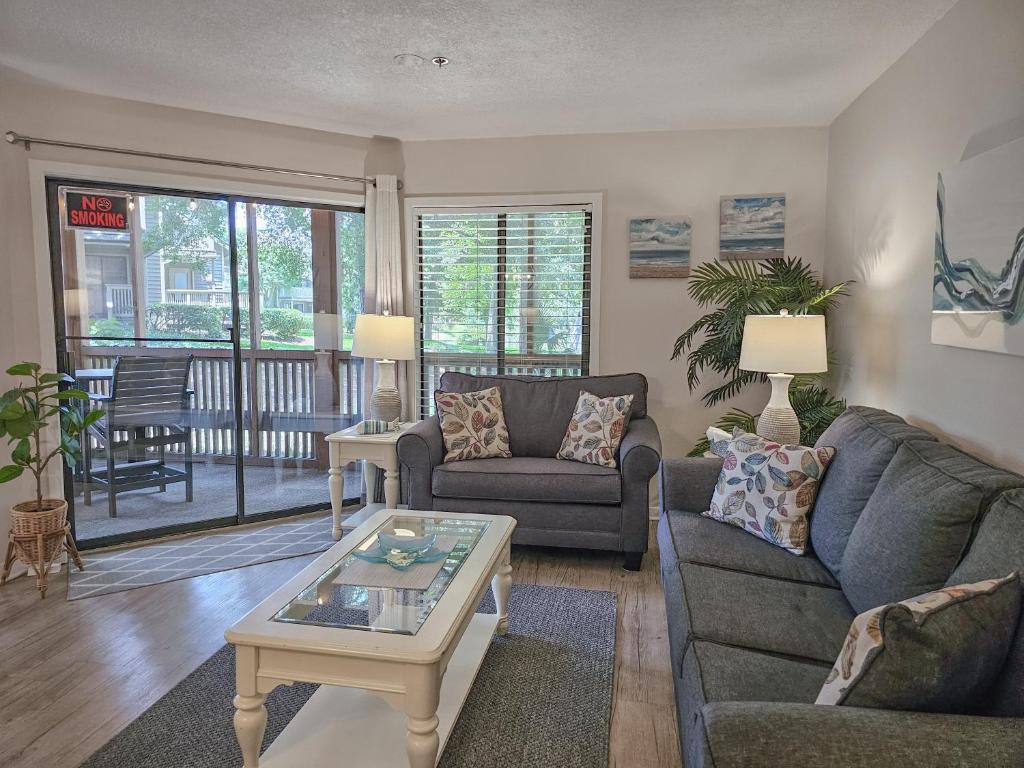 ein Wohnzimmer mit einer Couch und einem Tisch in der Unterkunft Serene 2 bed, 2 bath lodge, with amenities, 101AC lodge in Myrtle Beach