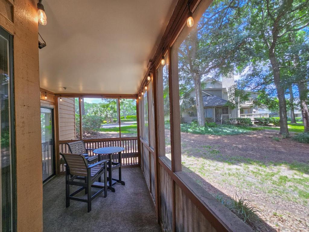 eine abgeschirmte Veranda mit einem Tisch und Stühlen darauf in der Unterkunft Serene 2 bed, 2 bath lodge, with amenities, 101AC lodge in Myrtle Beach
