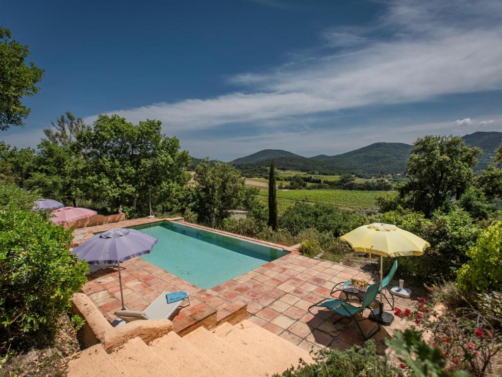 - une piscine avec deux parasols et des chaises dans l'établissement Entre les Vignes, à Emponse