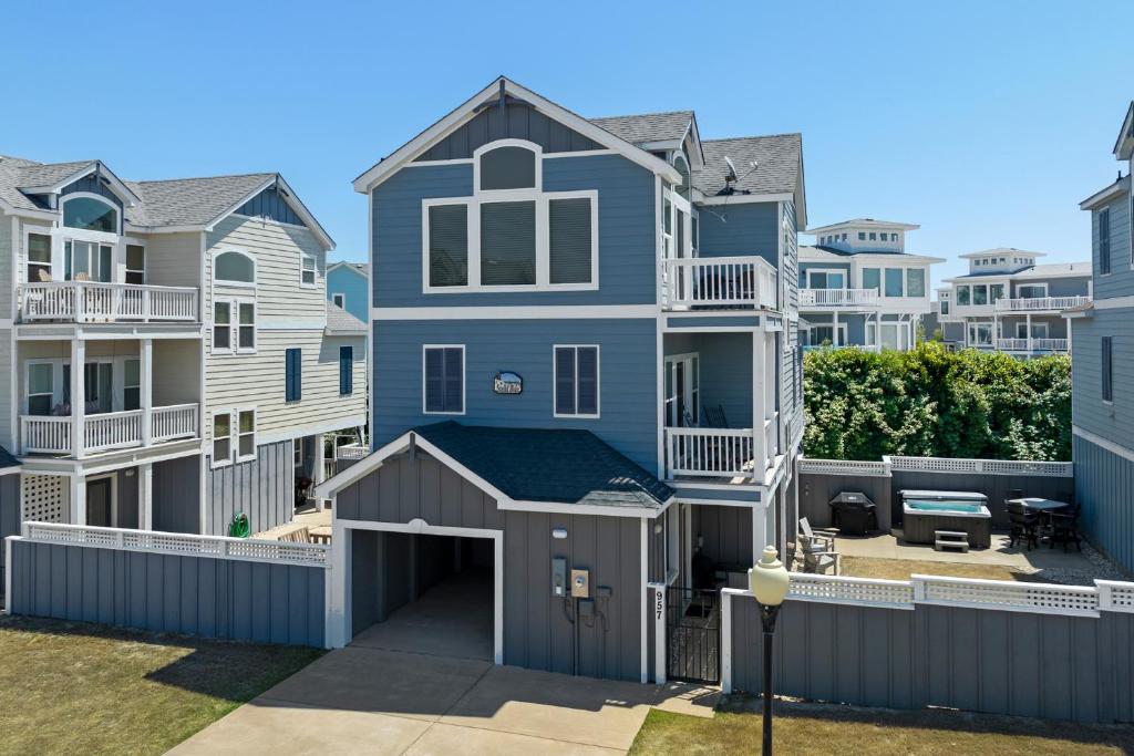 a blue house with a garage in front of houses at Stella Blue in Corolla