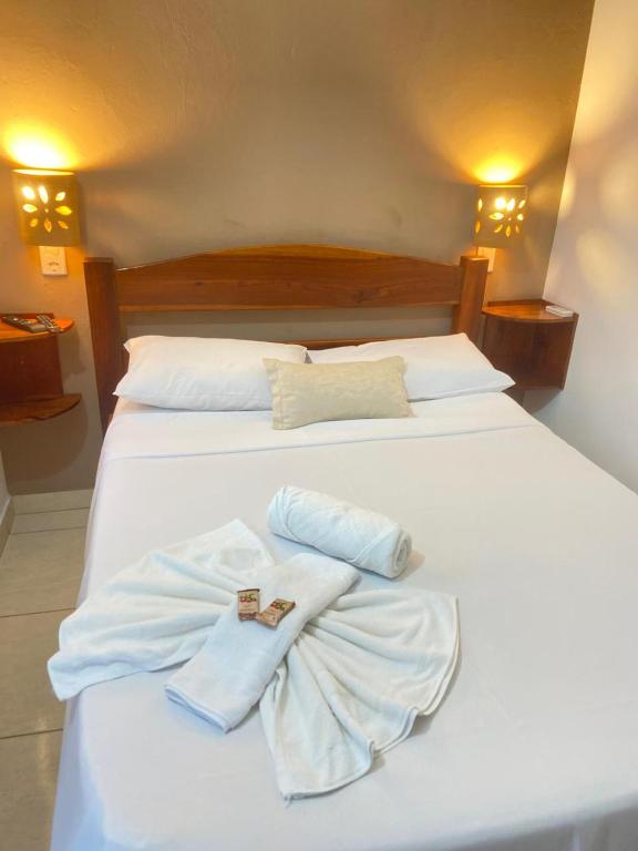 a white bed with two towels on top of it at Pousada Ilha Do Encanto in Ilha de Boipeba